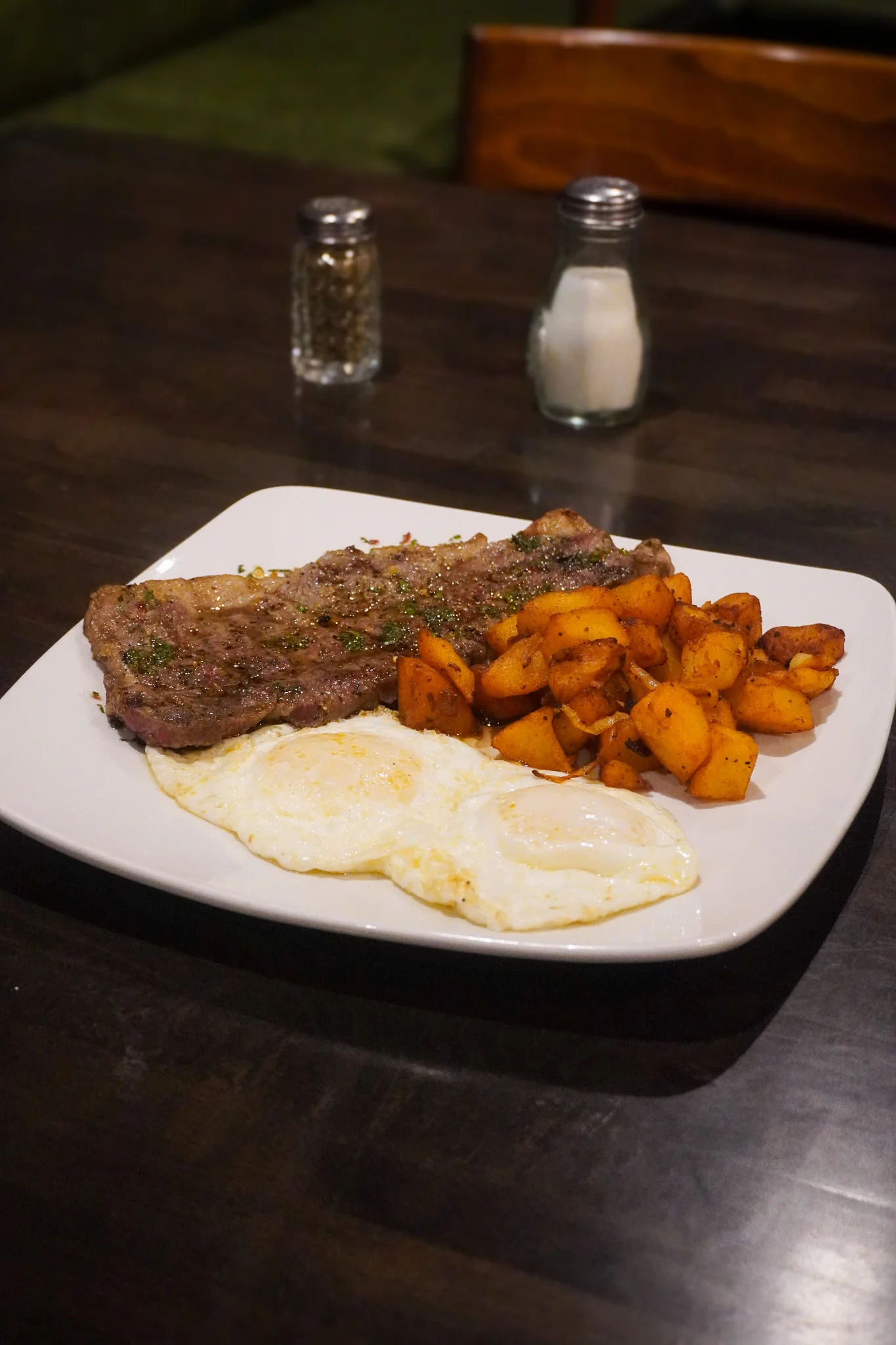 Hearty American breakfast with steak, eggs, and seasoned potatoes