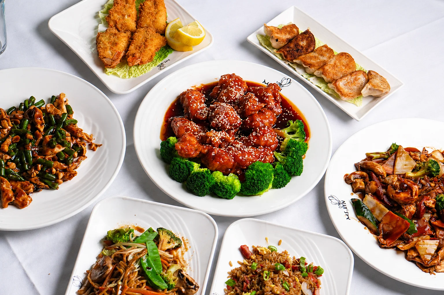 Assorted Chinese dishes including sesame chicken and dumplings