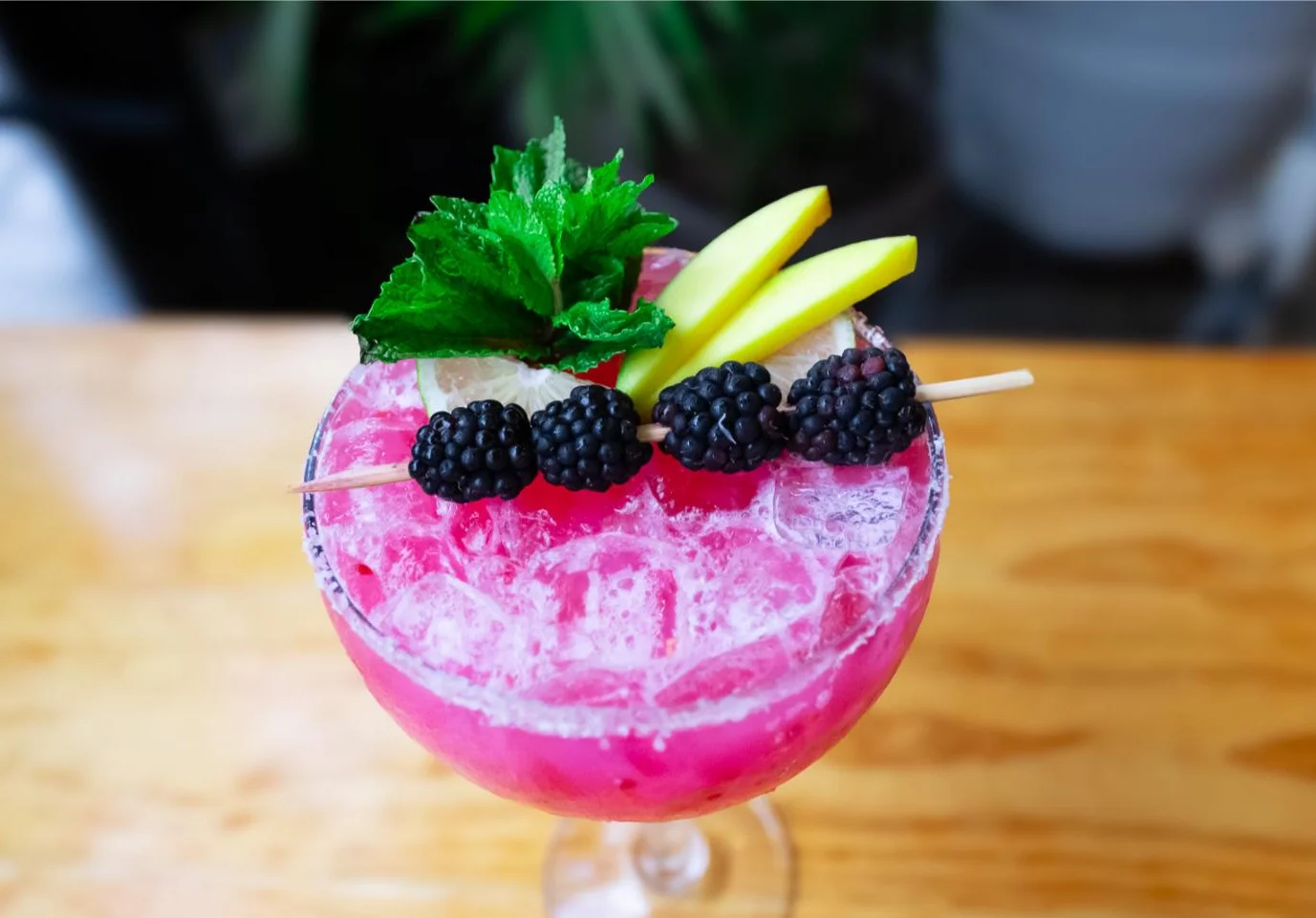 Vibrant cocktail garnished with mint and blackberries