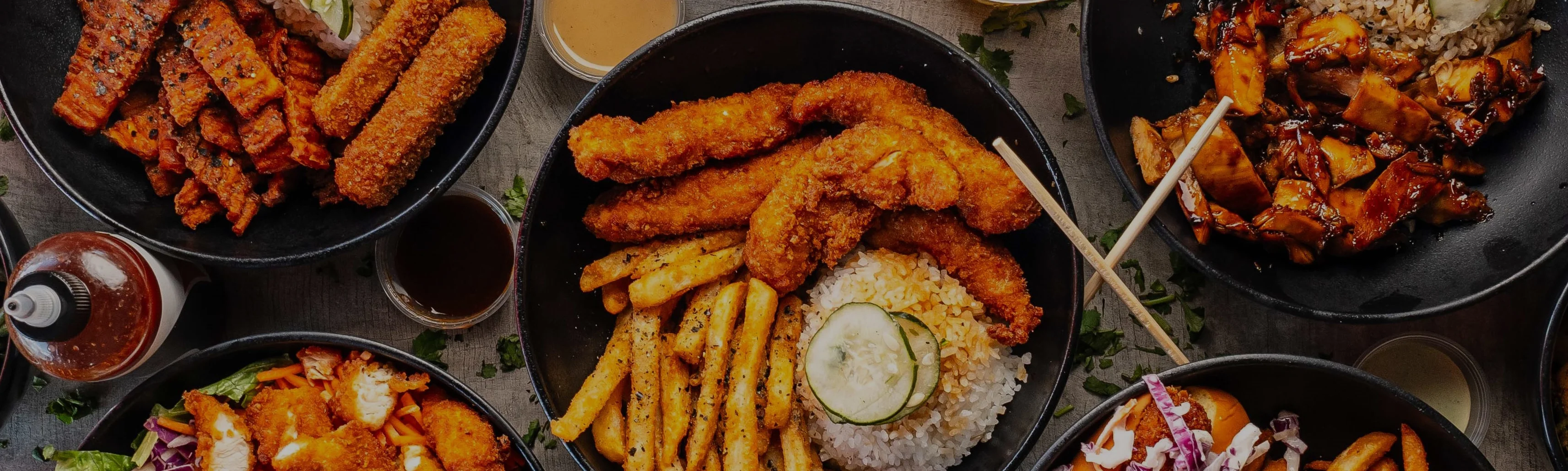 Assorted Asian-inspired dishes with fried chicken and rice