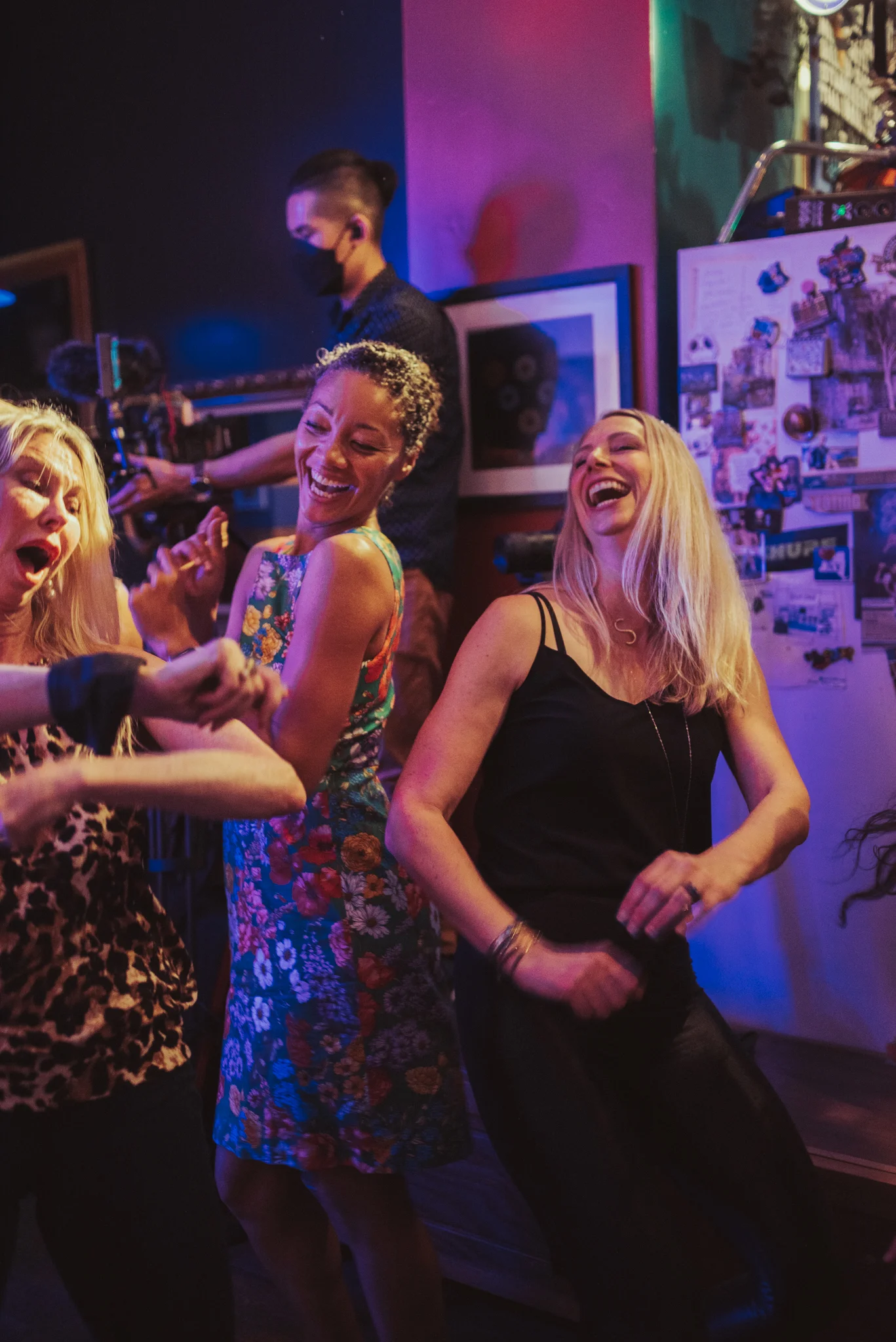 Group of friends dancing joyfully in a vibrant bar setting