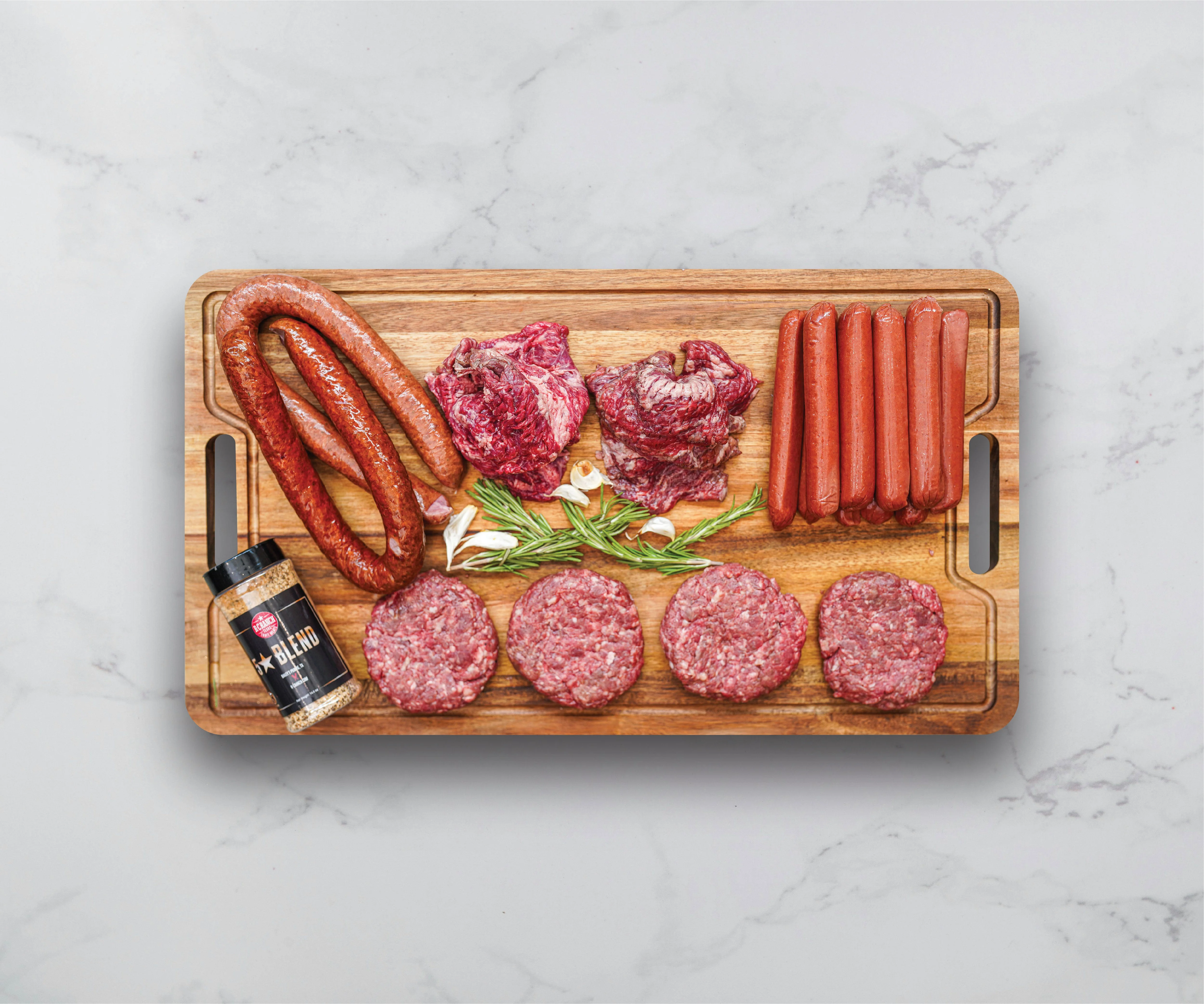 Assorted meats for grilling on a wooden cutting board
