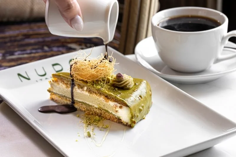 Pistachio cake with coffee in a stylish restaurant setting