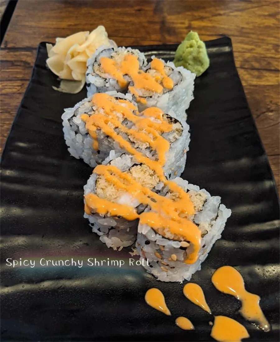 Japanese spicy crunchy shrimp roll on a black plate
