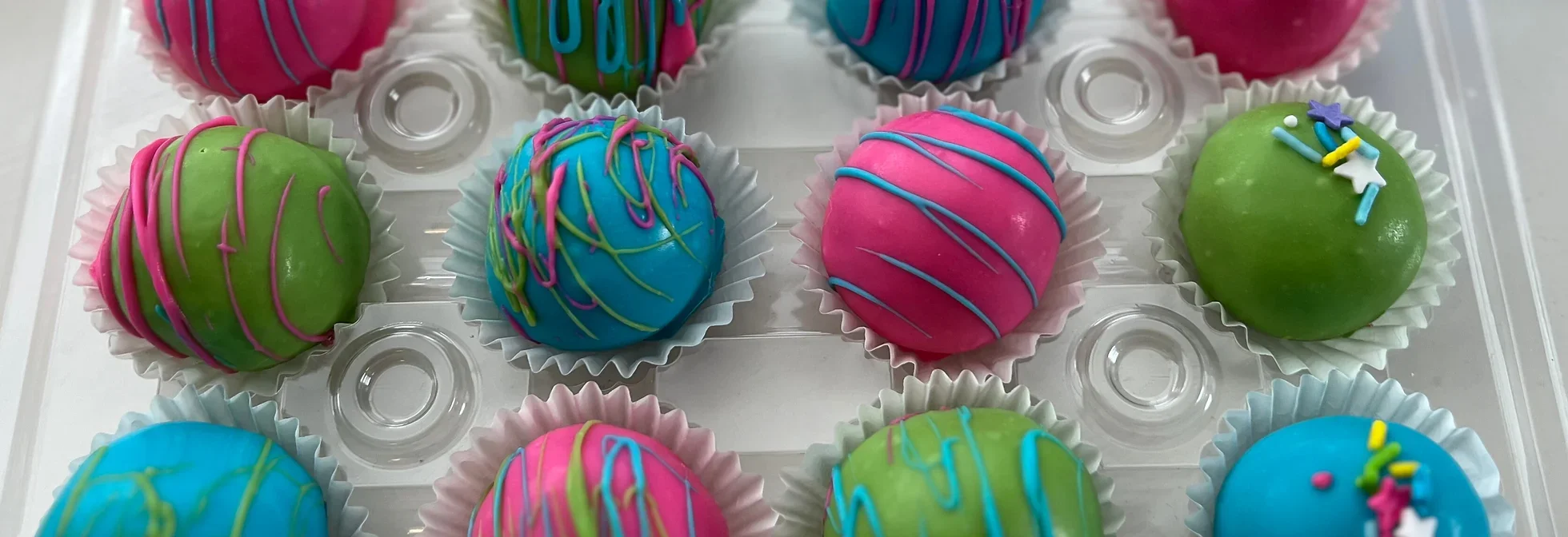Colorful cake pops in vibrant hues and decorative icing