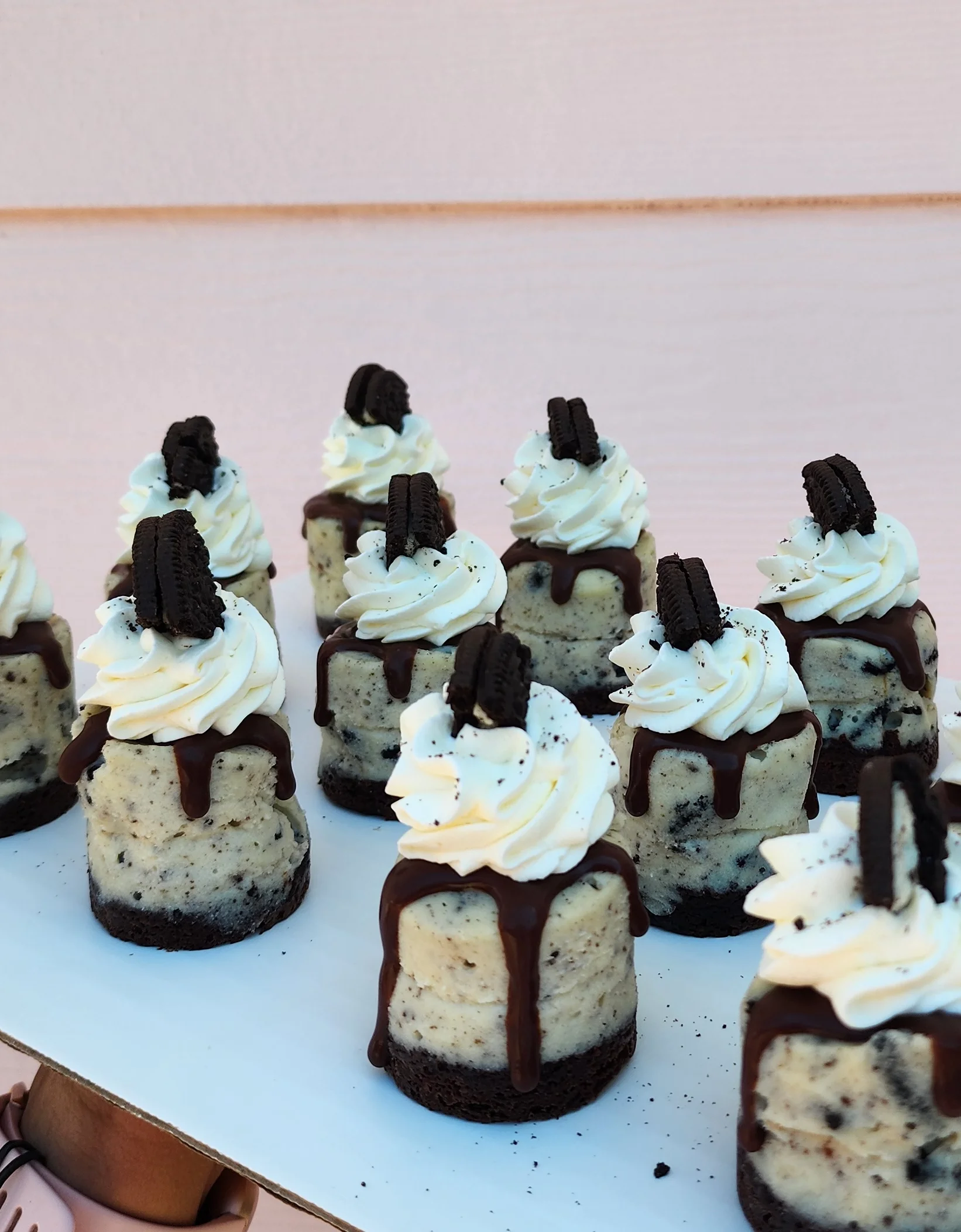 Mini Oreo cheesecakes with whipped cream and chocolate drizzle