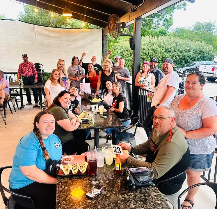 Group of friends enjoying a meal at a lively outdoor restaurant