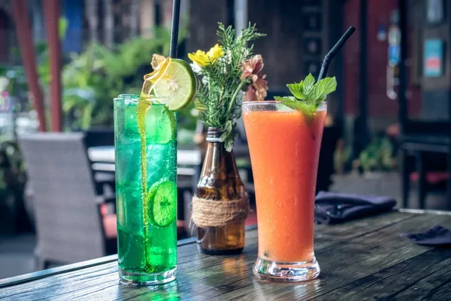 Refreshing cocktails on a wooden table in a vibrant restaurant setting