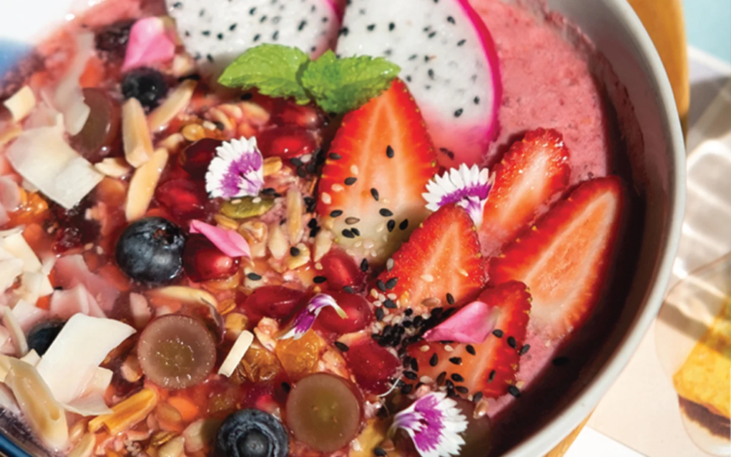 Colorful smoothie bowl with fresh fruits and edible flowers