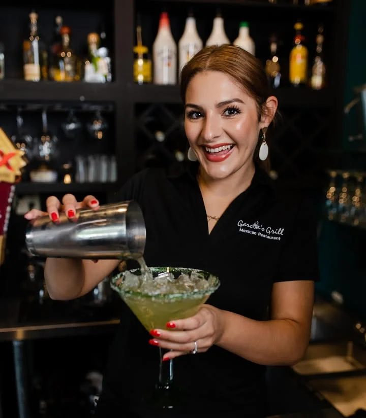 Bartender preparing a cocktail at a vibrant bar counter
