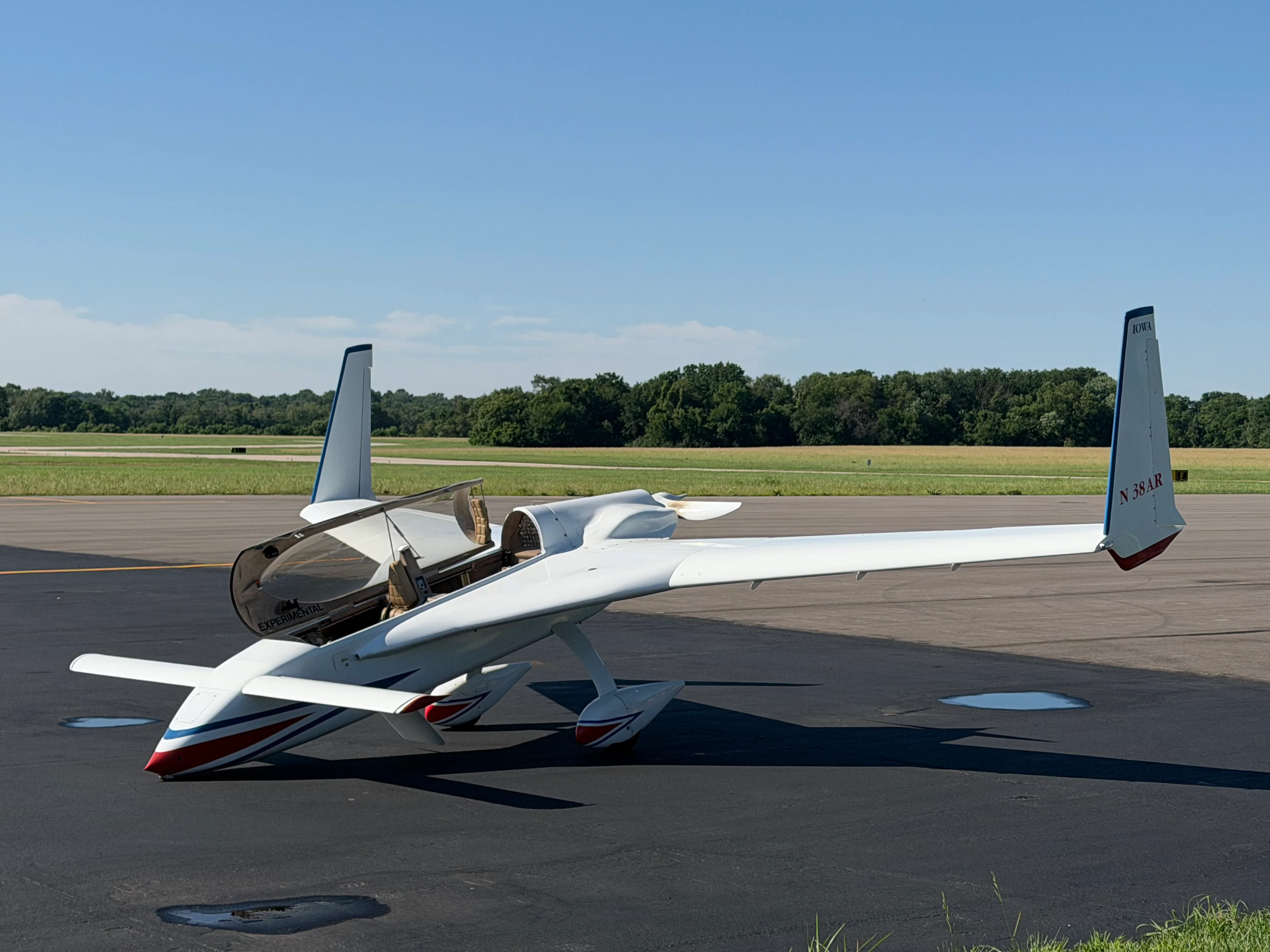 Experimental aircraft on runway under clear blue sky
