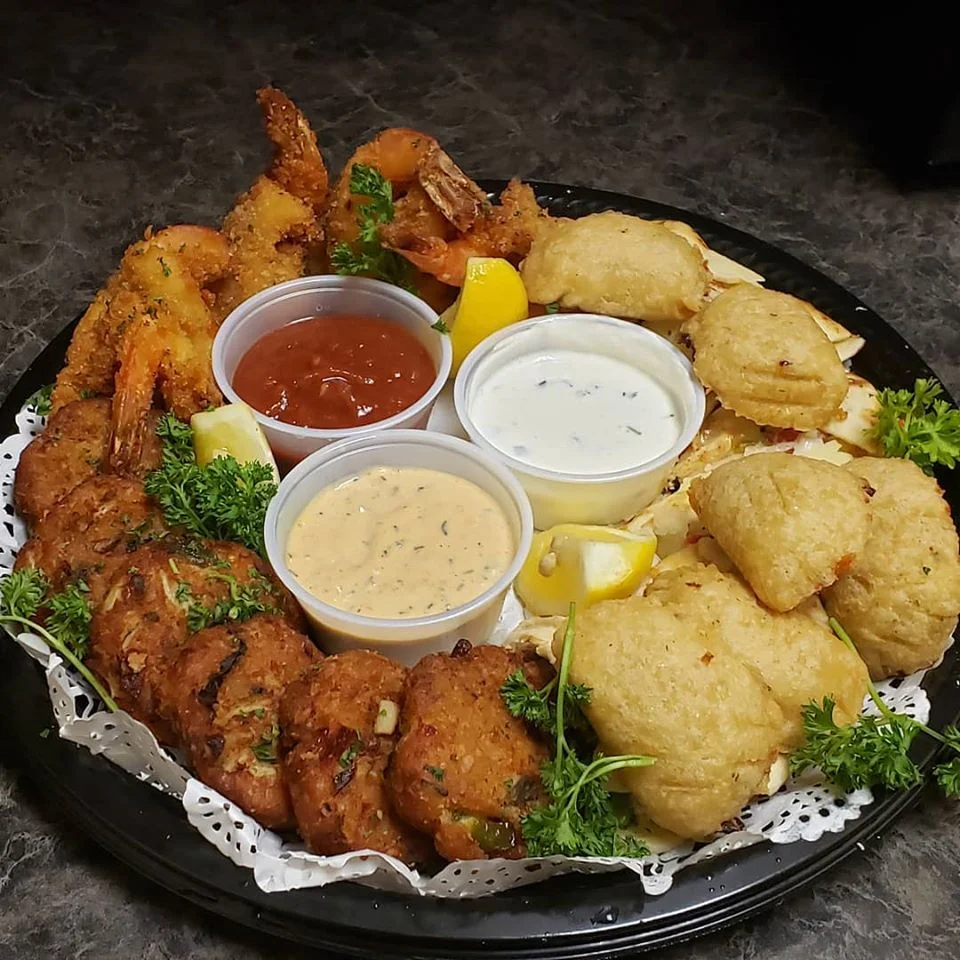 Corporate takeout appetizers from Post Oak Grill Downtown Houston featuring crab cakes, crispy shrimp, and empanadas.