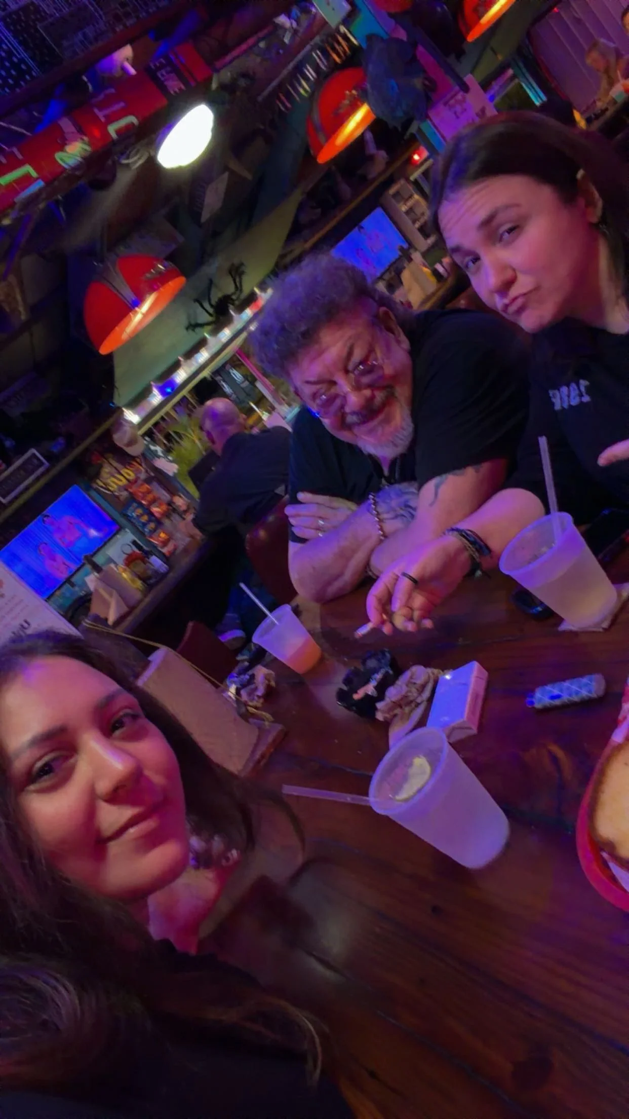 Friends enjoying drinks at a lively bar with colorful decor