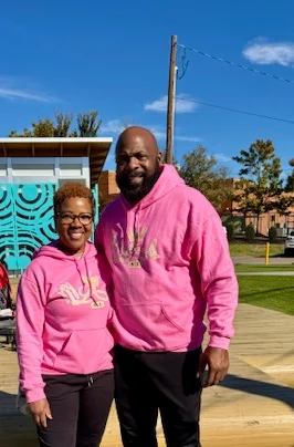 Couple in matching pink hoodies at a park