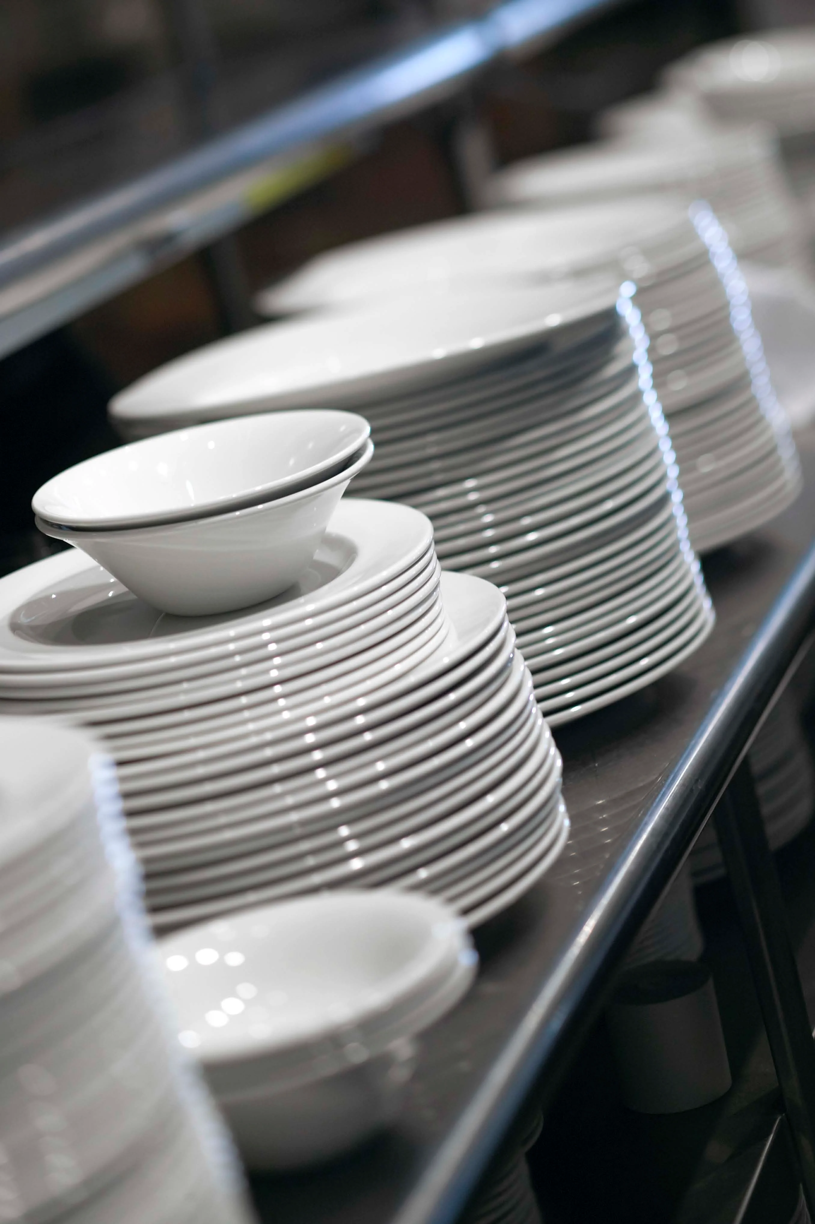 Stacked white dinnerware in a restaurant kitchen