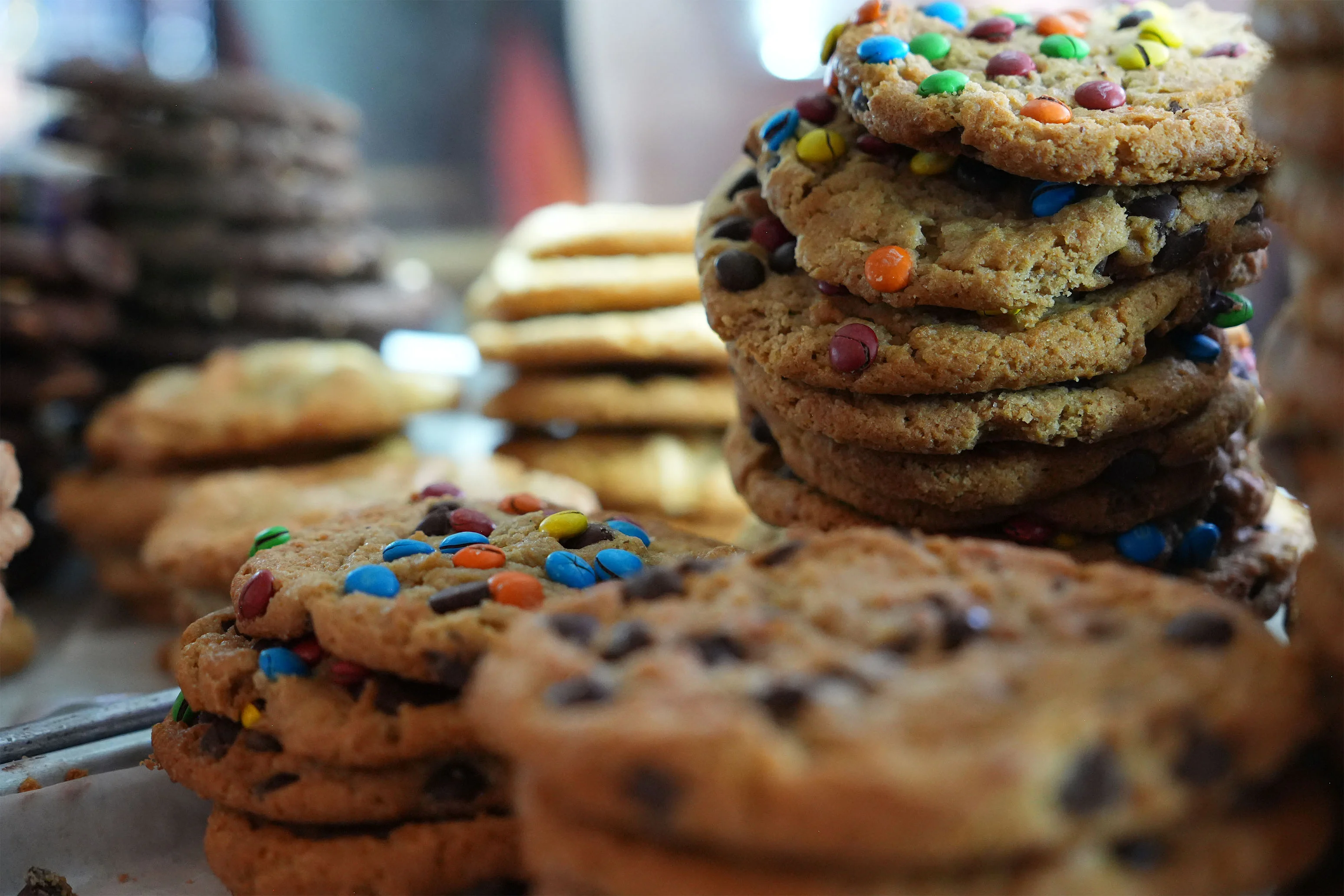 Stack of colorful M&M cookies at a bakery