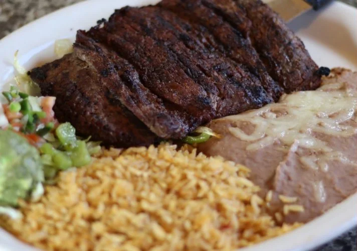 Delicious carne asada served with rice and beans