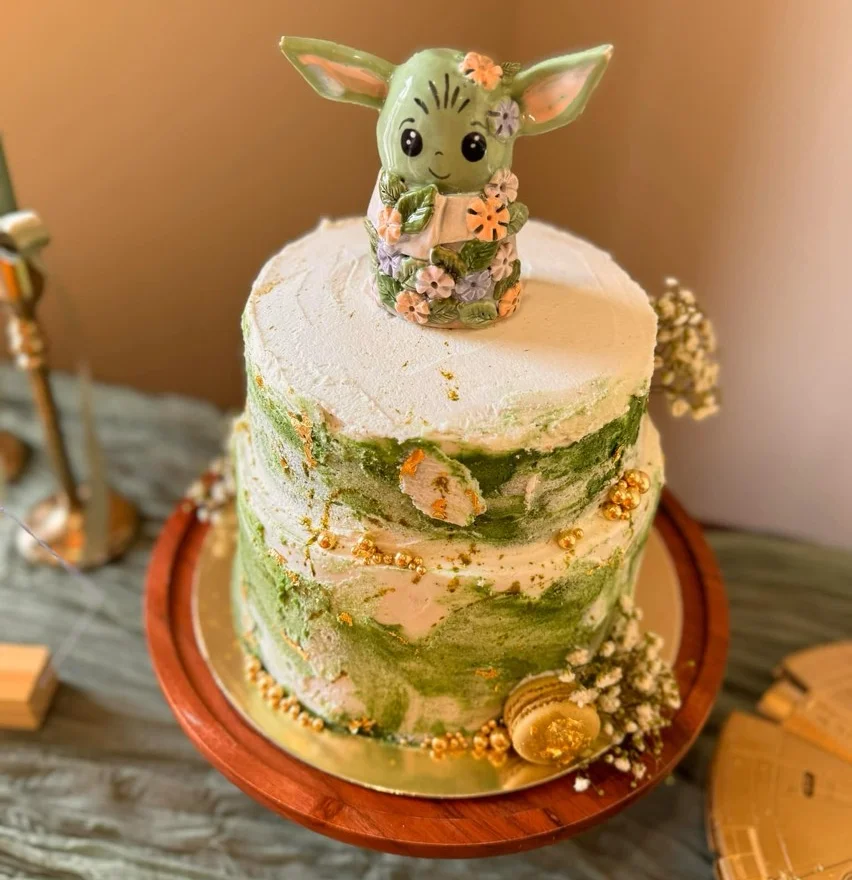 Whimsical cake topped with a floral figurine in pastel colors