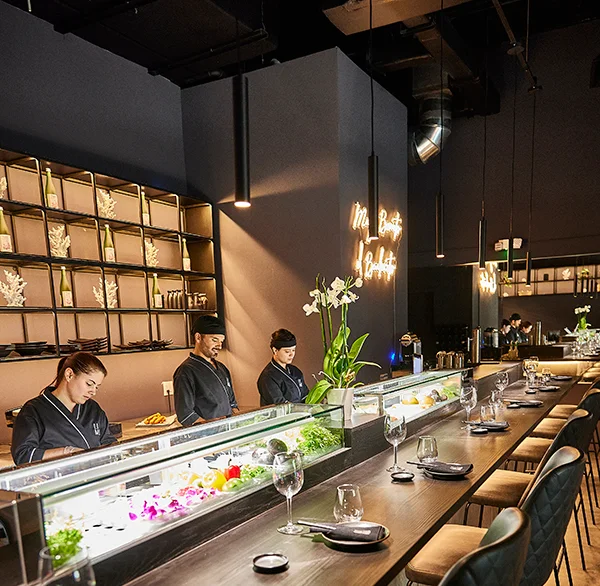 Modern sushi bar interior with chefs preparing fresh sushi