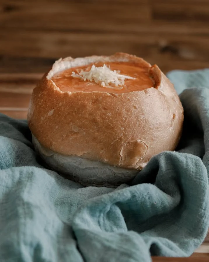 Bread bowl filled with creamy tomato soup