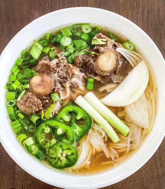 Bowl of Vietnamese pho with beef and fresh herbs