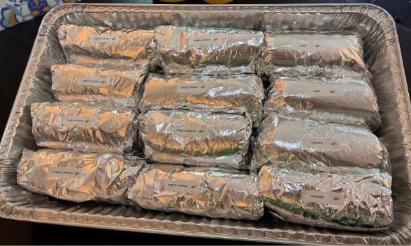Assorted burritos wrapped in foil for catering
