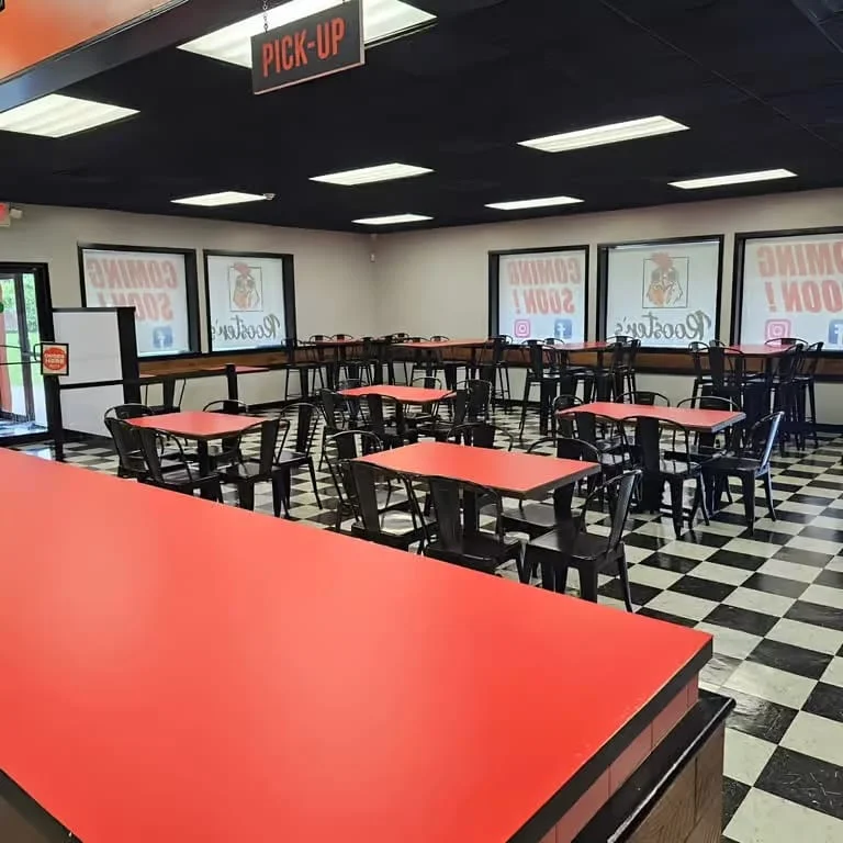 Modern restaurant interior with red tables and black chairs
