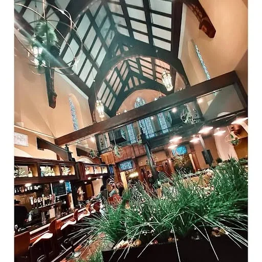 Elegant restaurant interior with high ceilings and greenery