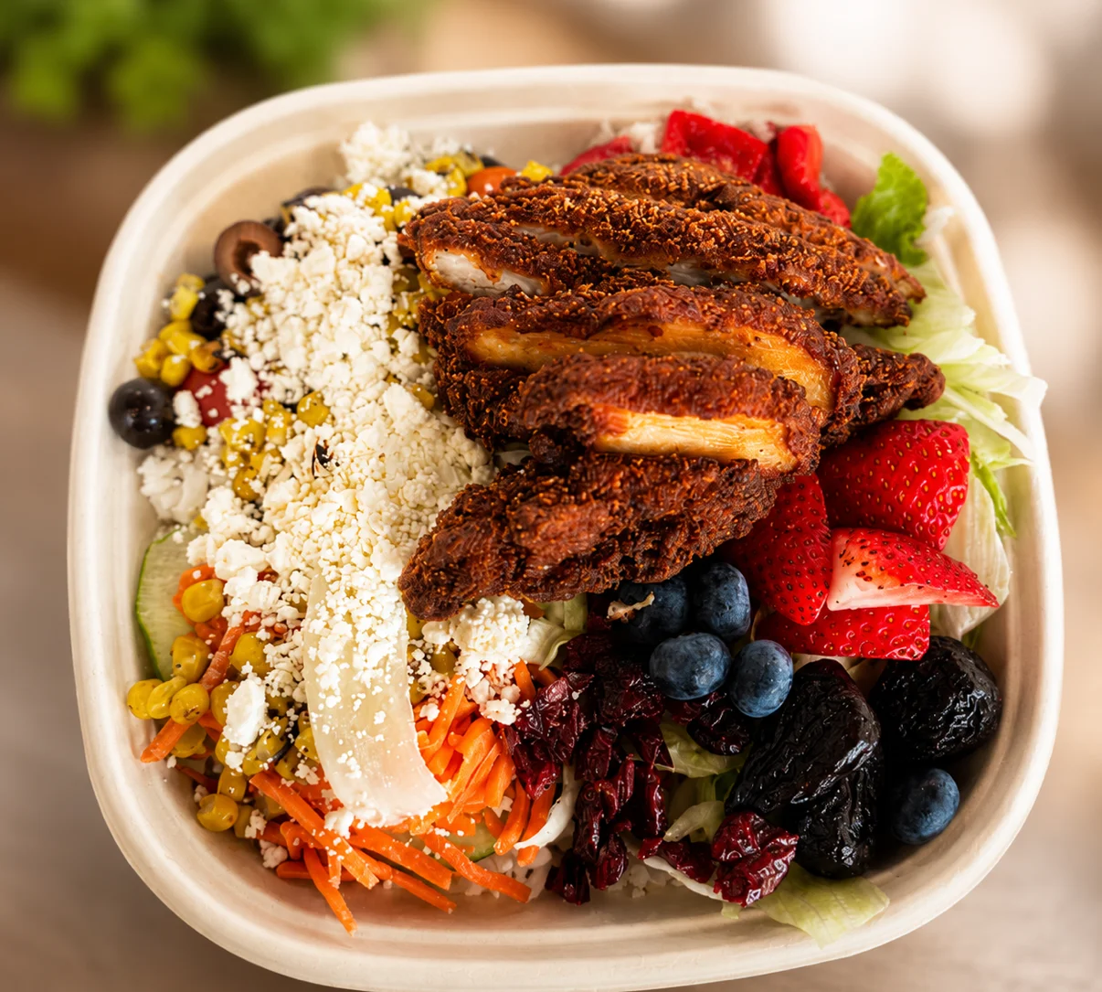 Crispy chicken salad bowl with fresh fruits