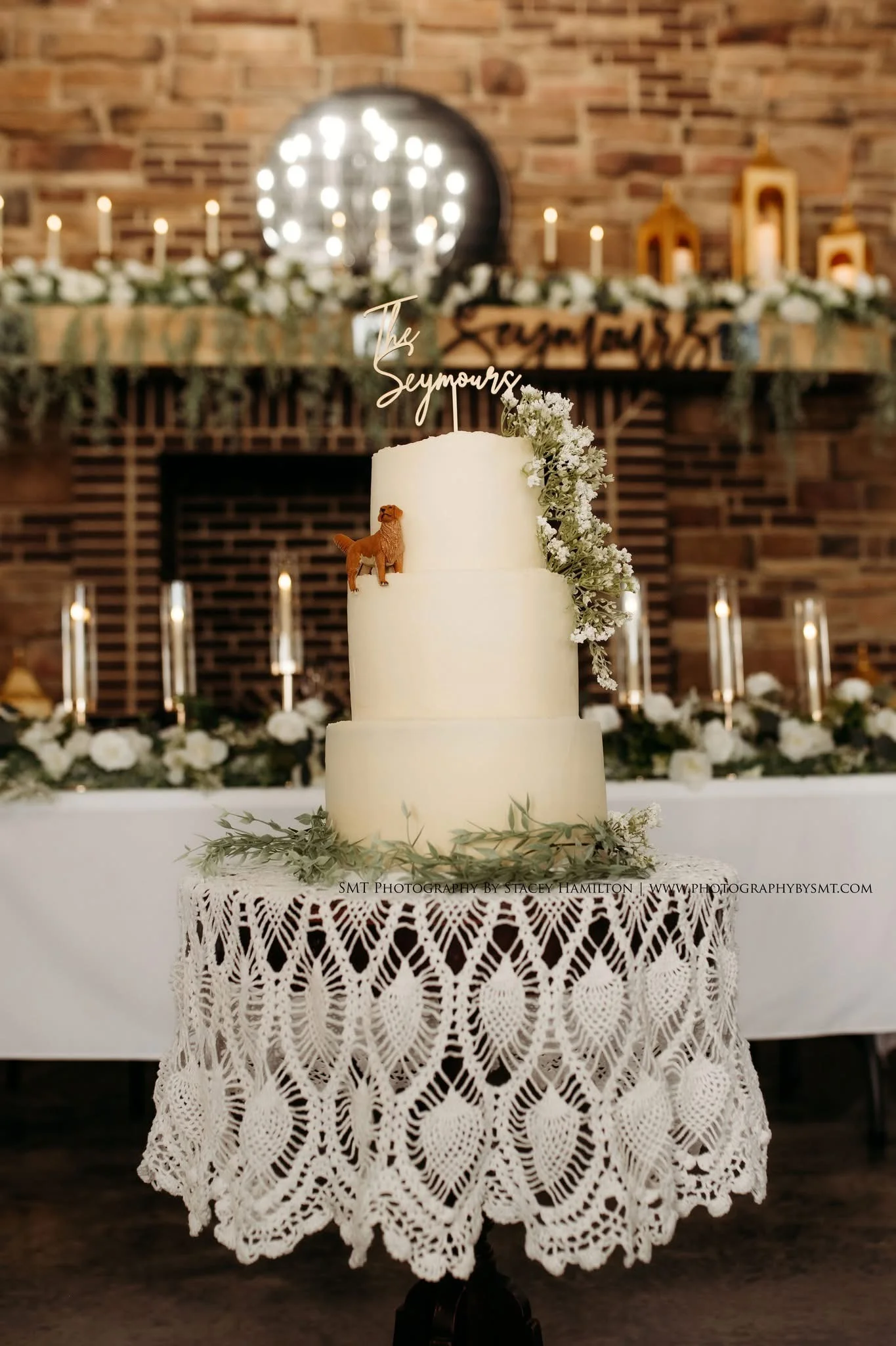 Elegant wedding cake with floral decor and a dog figurine