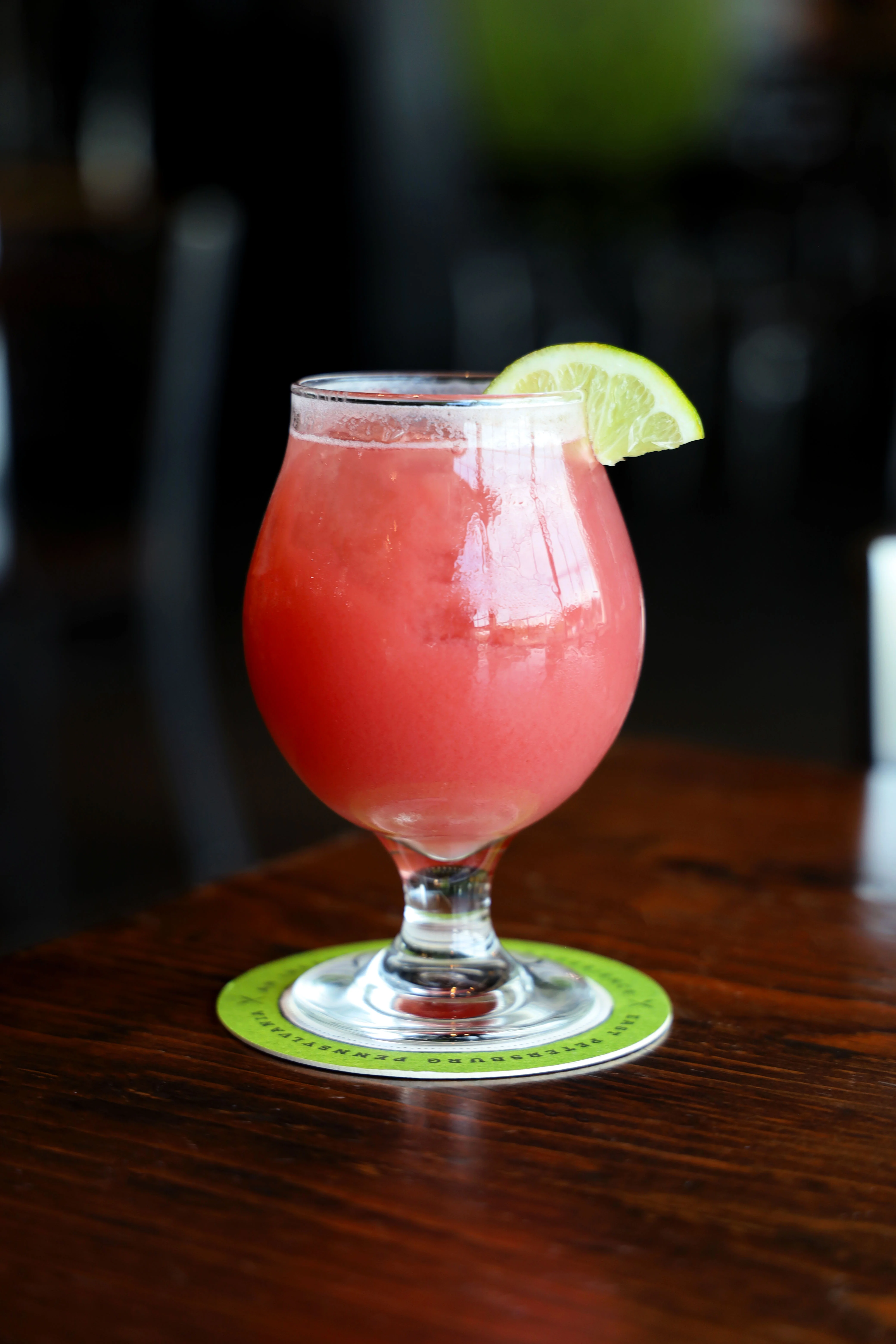 A refreshing Hibiscus Hop Water in a clear glass with a vibrant color.