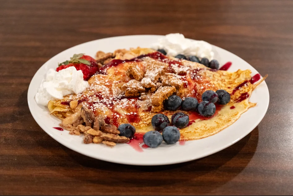 Delicious crepes with berries and whipped cream