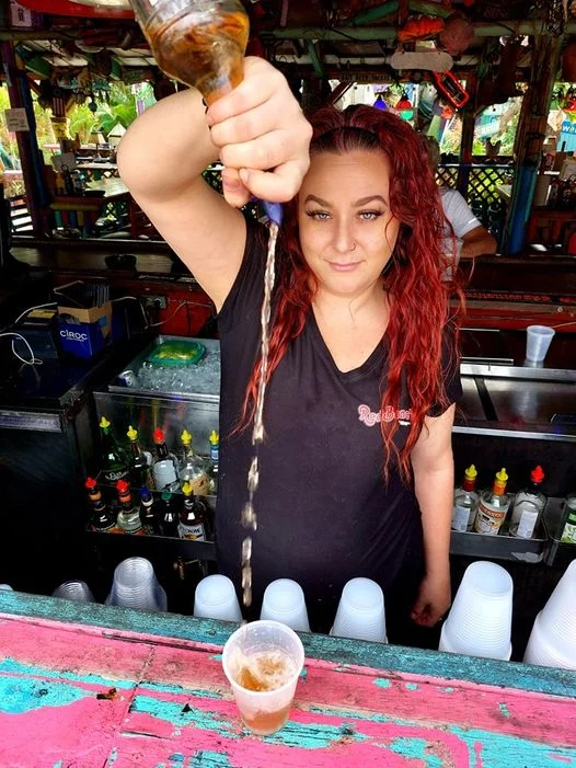 Bartender pouring a cocktail at a vibrant bar