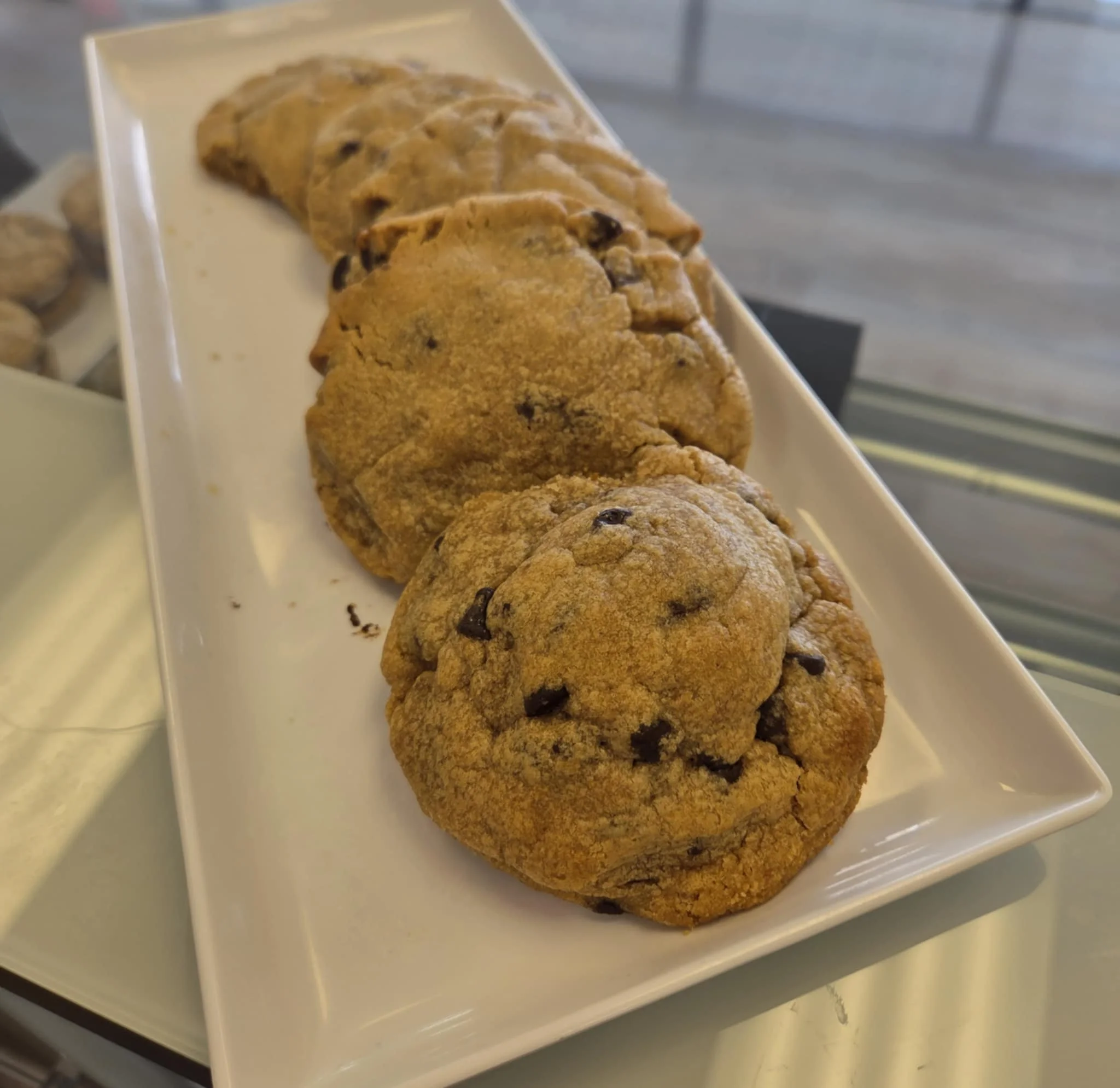 Freshly baked chocolate chip cookies on a white platter