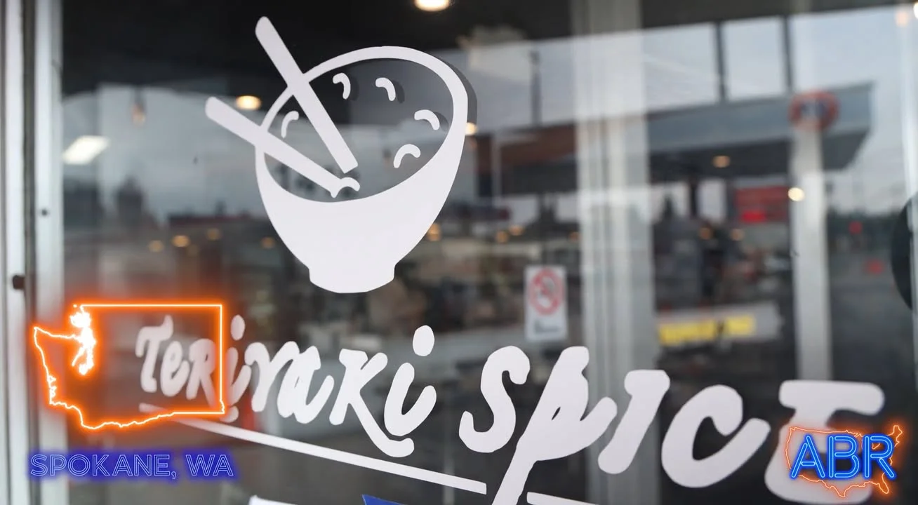 A storefront window displaying the logo of a teriyaki restaurant.