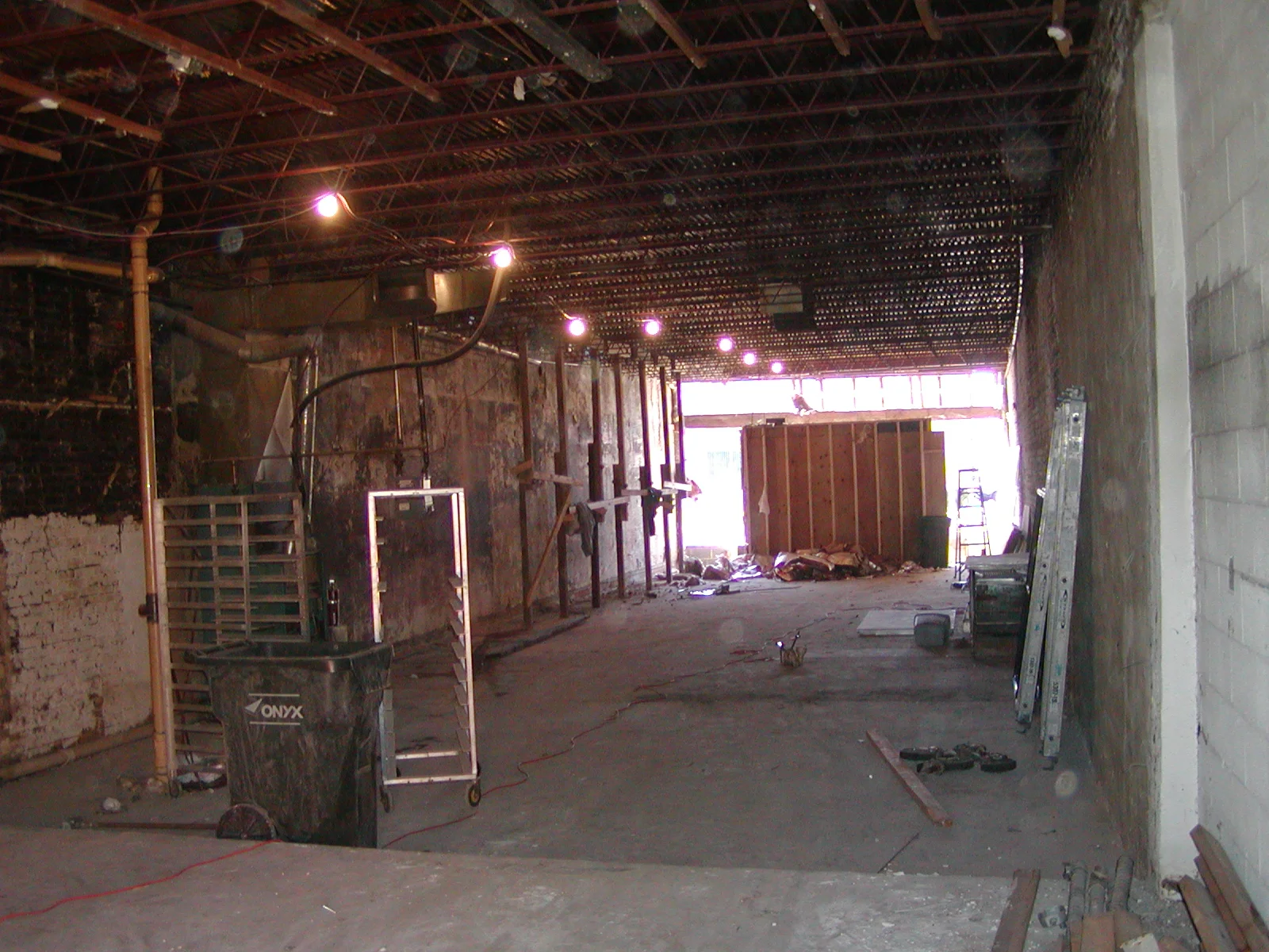Empty restaurant interior during renovation with exposed walls and lighting