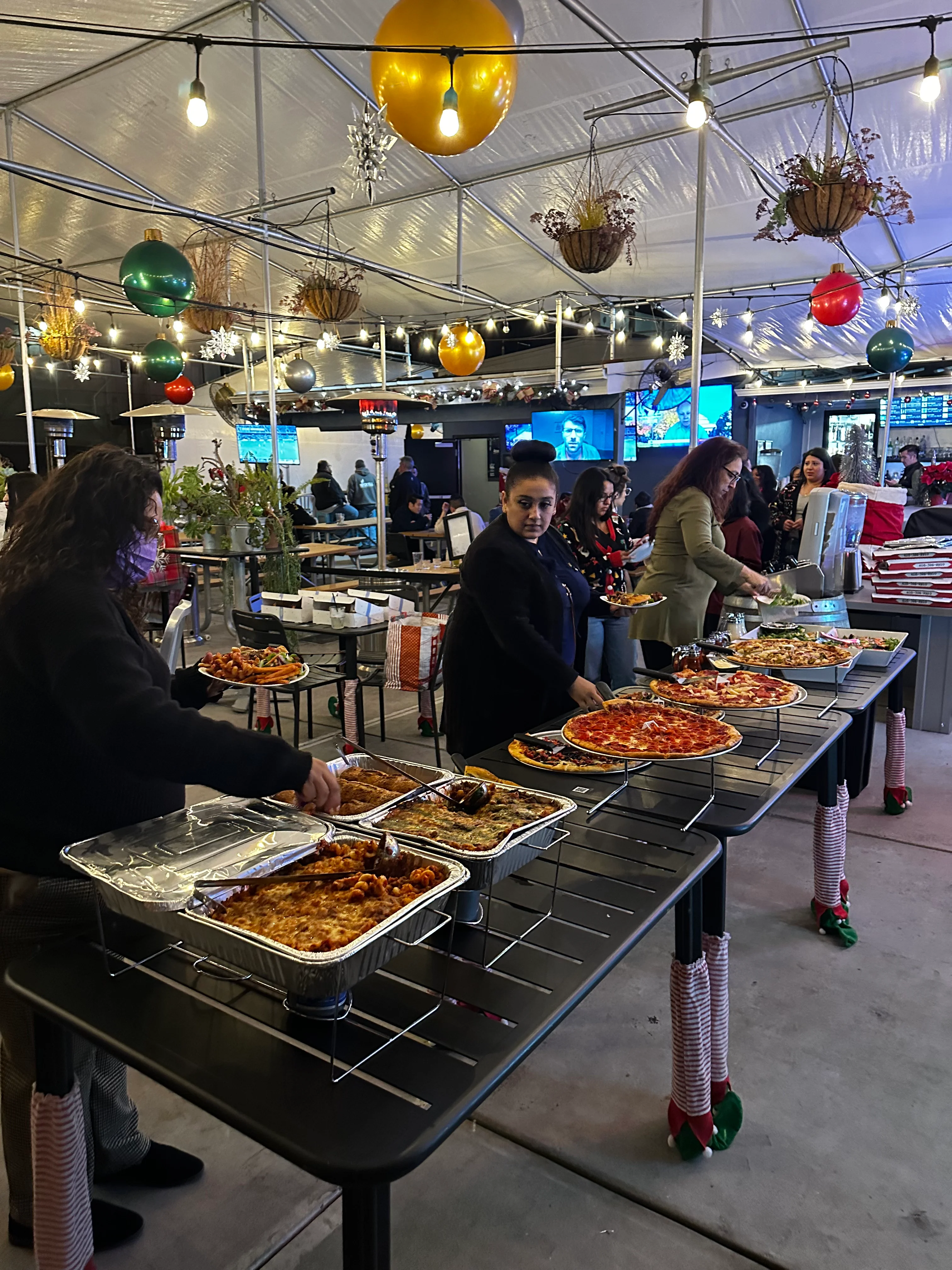 Festive buffet with assorted pizzas and Italian dishes at a lively restaurant