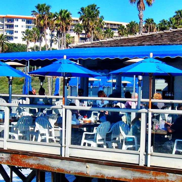 Seaside restaurant with blue umbrellas and ocean view