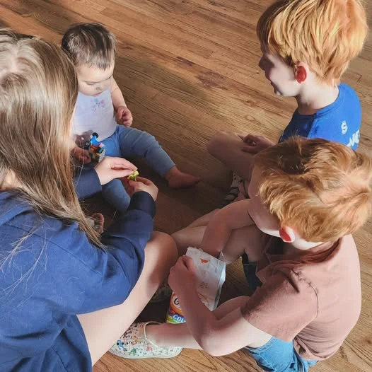 Children playing together with toys on wooden floor