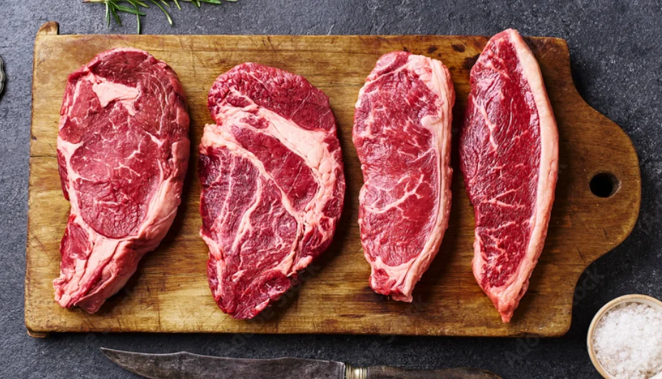 Selection of premium ribeye steaks on a wooden cutting board
