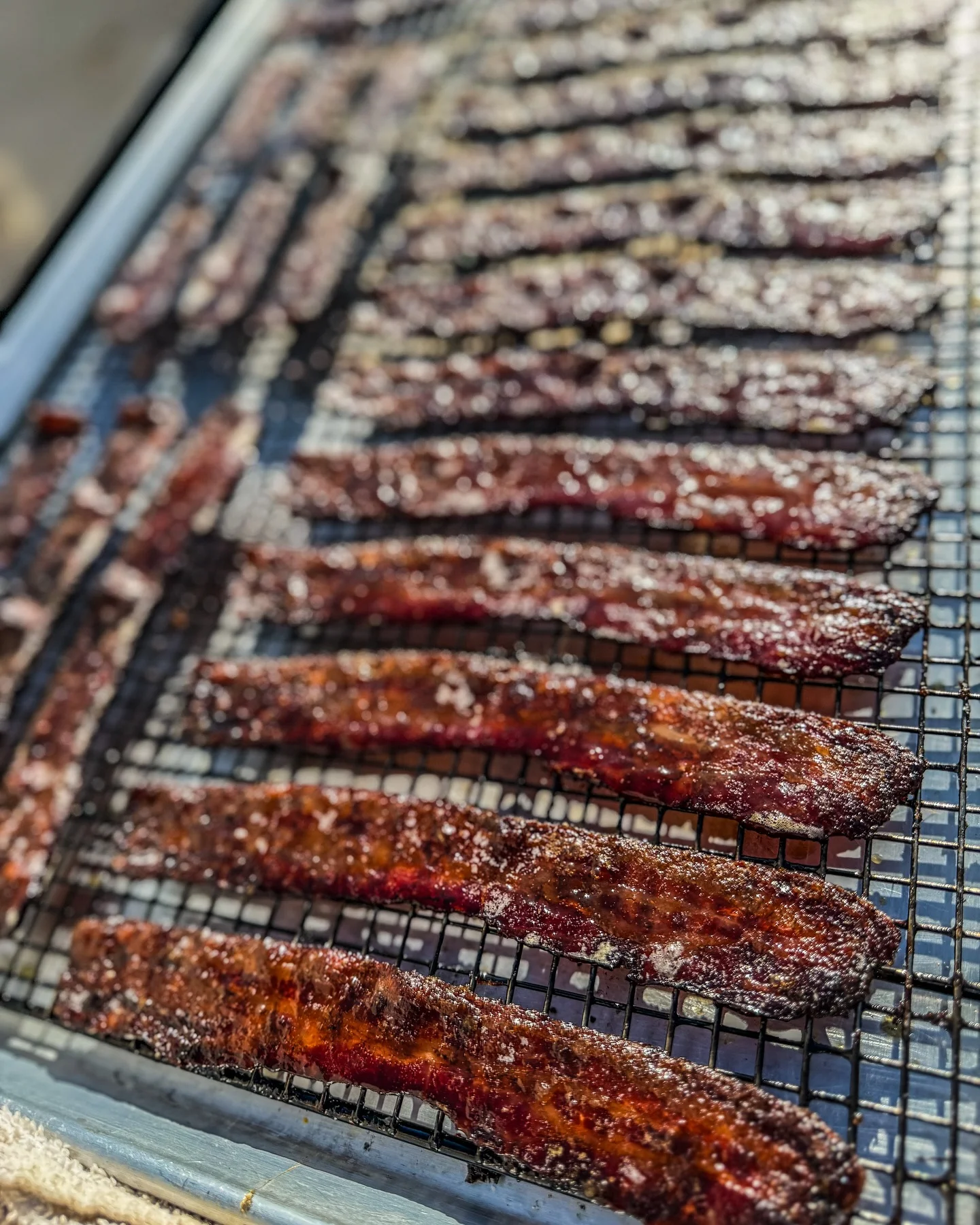 Sweet and savory Korean beef jerky strips drying on a rack
