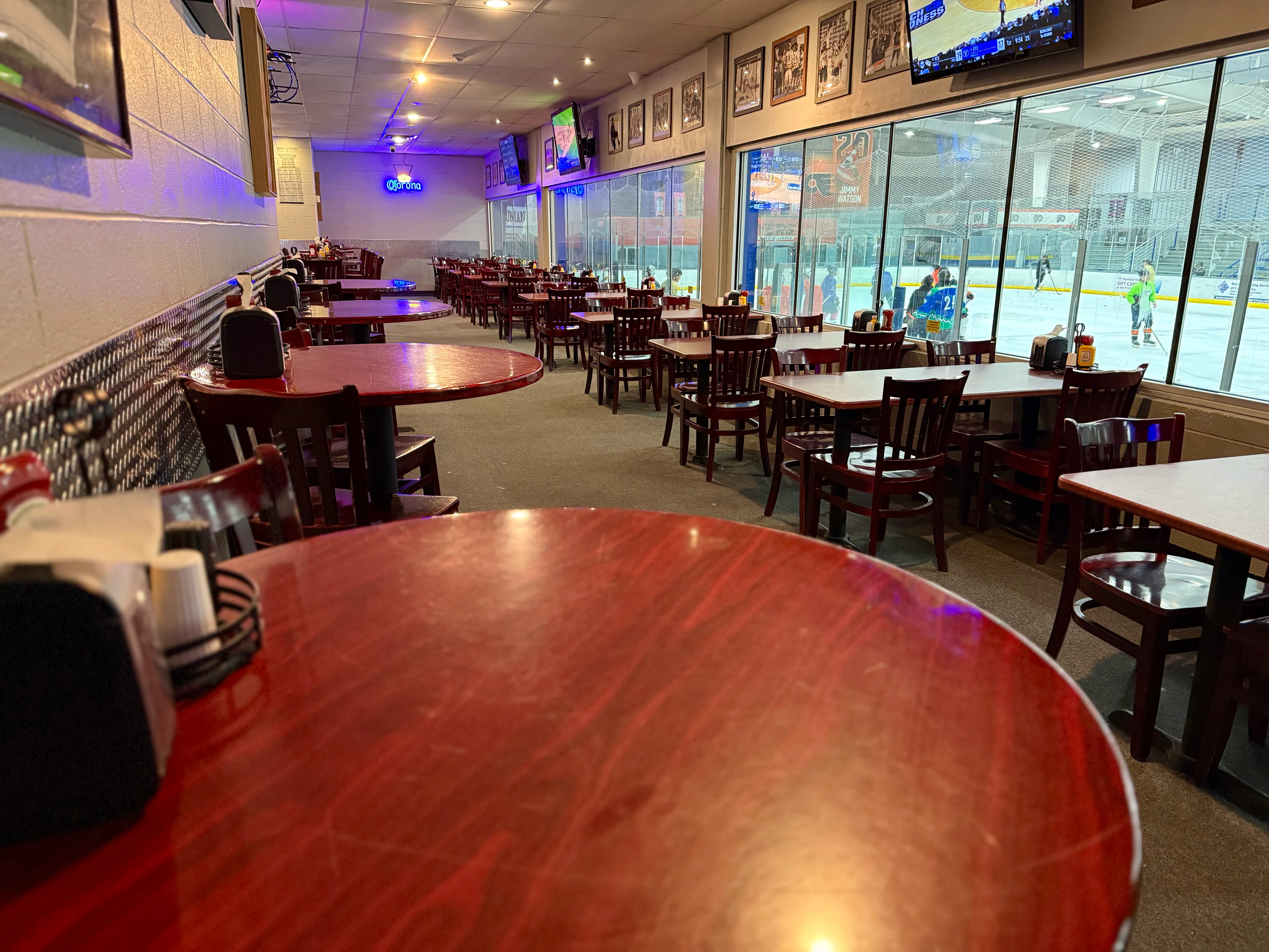 Cozy restaurant interior with tables overlooking an ice rink