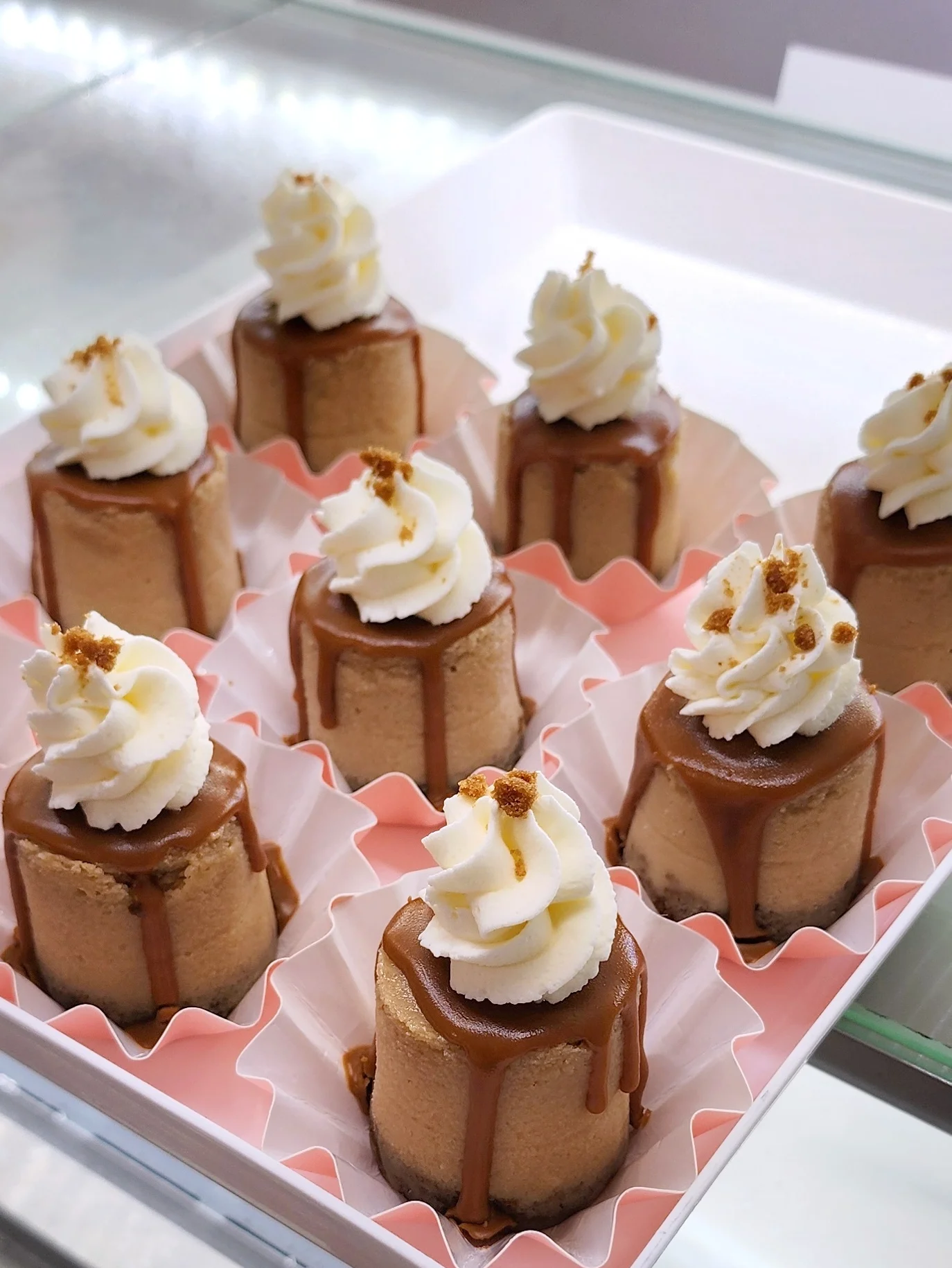 Mini caramel cheesecakes topped with whipped cream