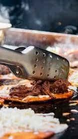 Sizzling street tacos with beef on a griddle