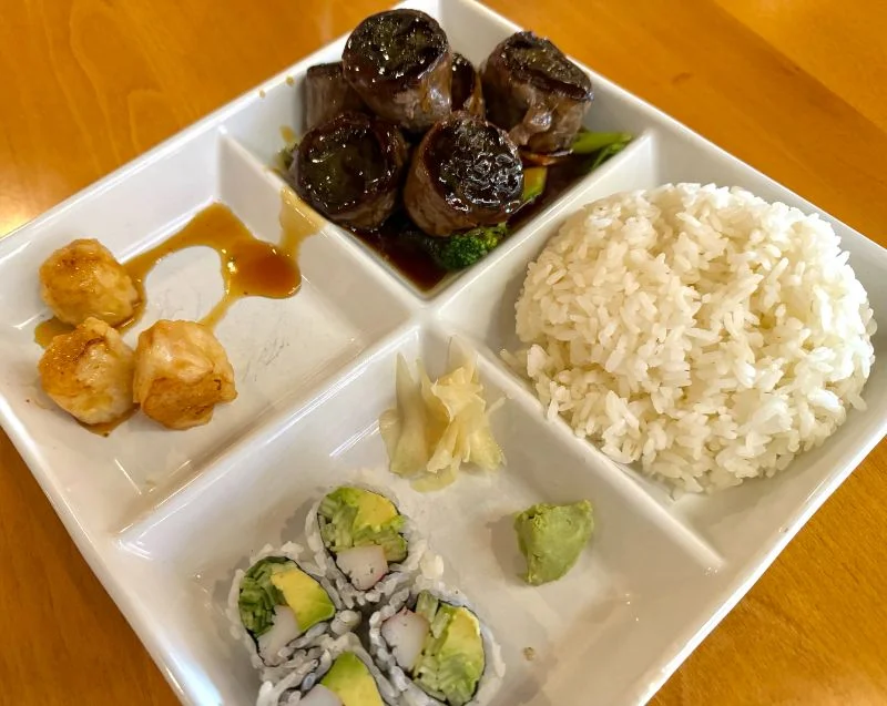 Japanese bento box with sushi, rice, and teriyaki beef
