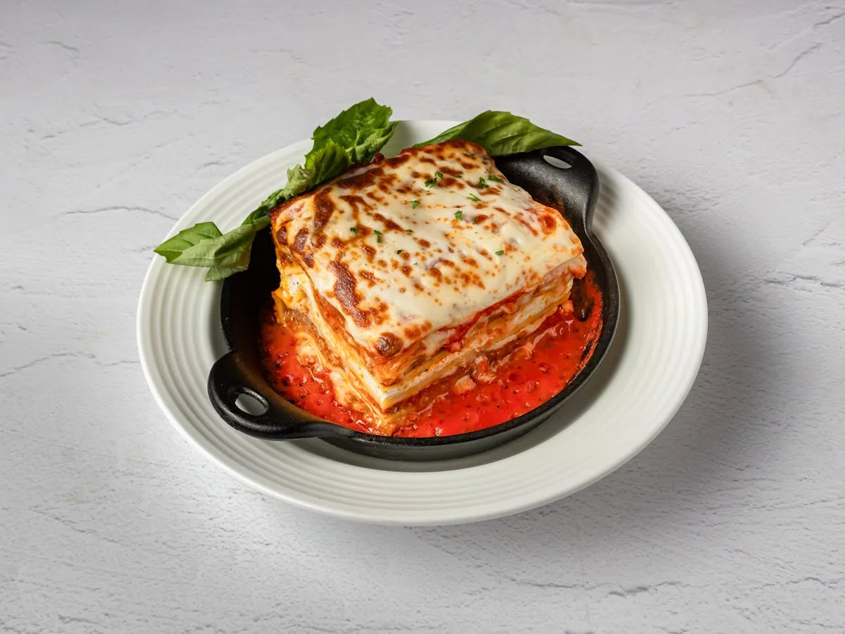 Homemade lasagna with marinara and fresh basil — Italian comfort food at Amici, West Palm Beach