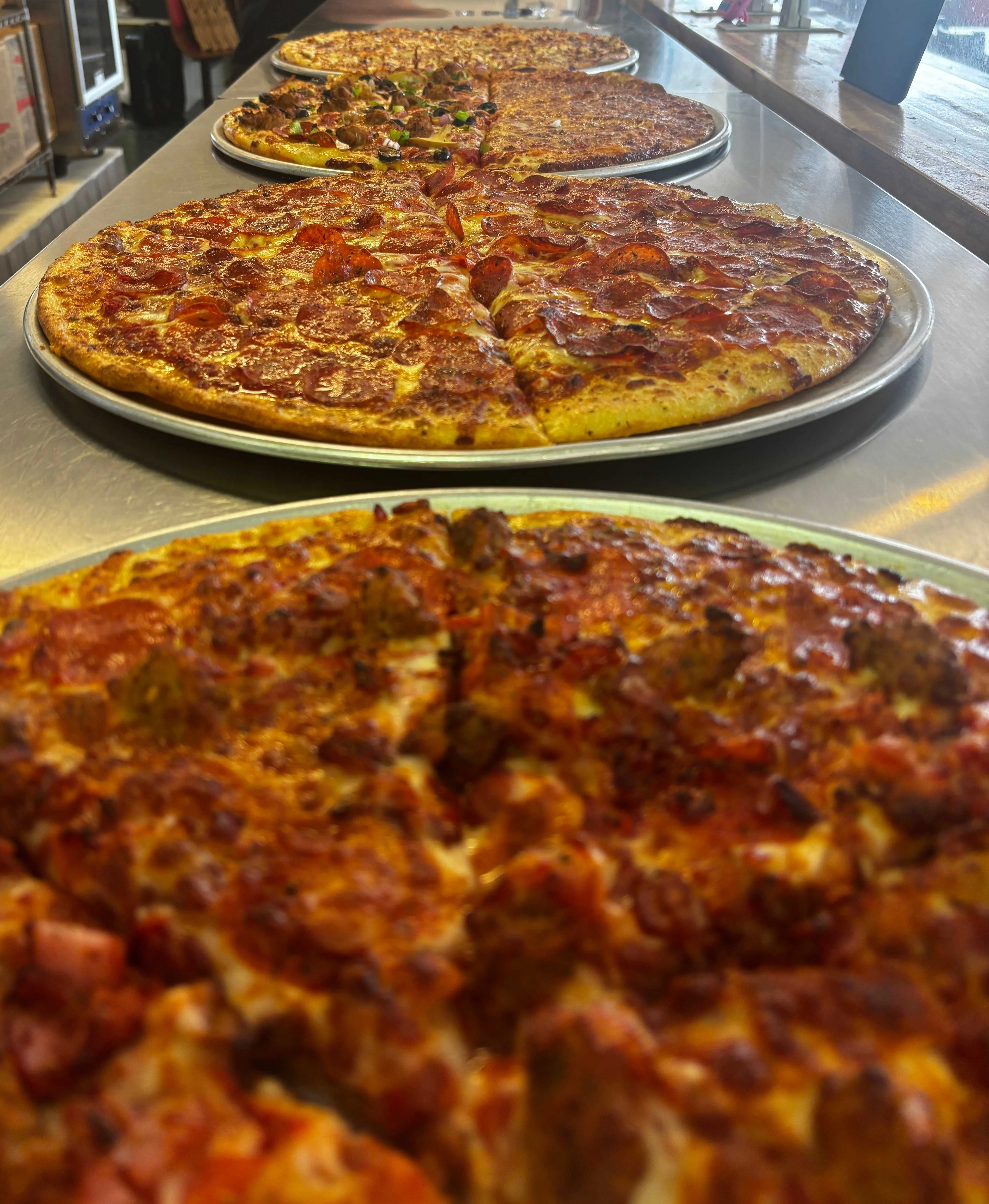 Variety of delicious pizzas on display at a pizzeria