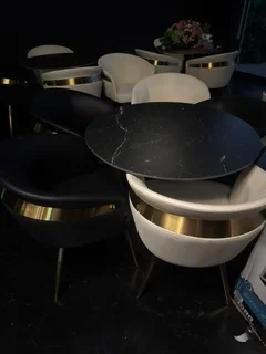 Elegant dining setup with black and white chairs and marble tables