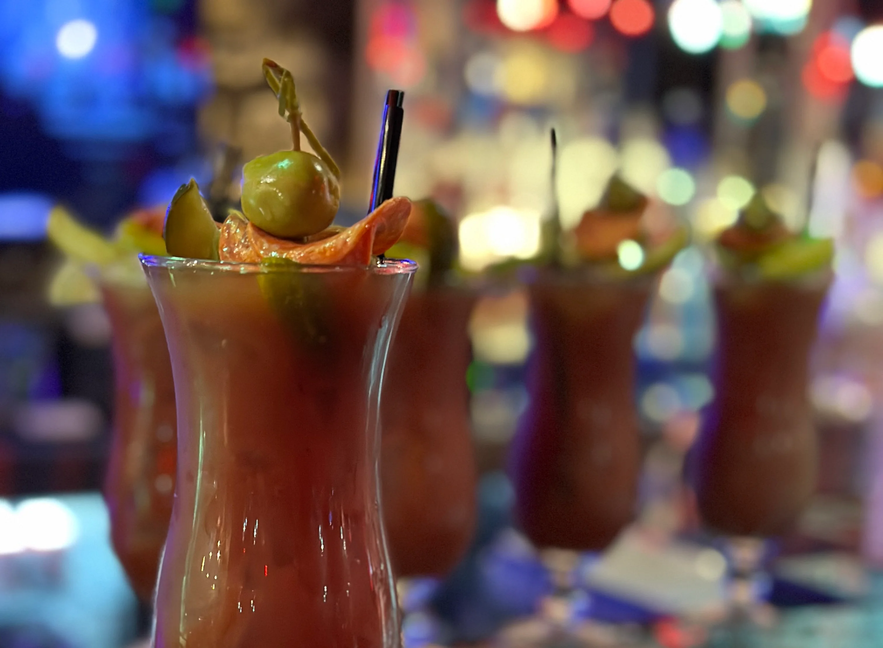 A vibrant Bloody Mary cocktail garnished with celery and spices.