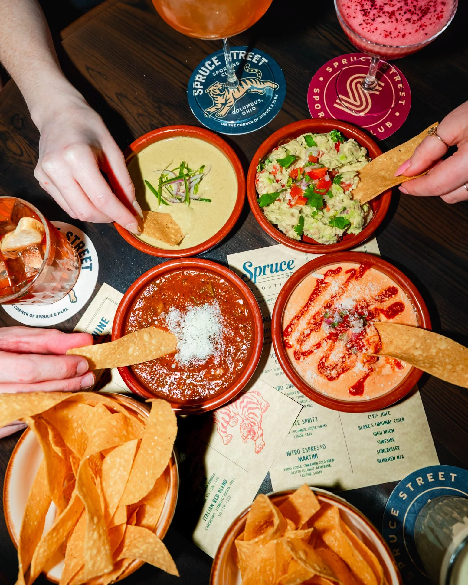 Assorted Mexican dips with tortilla chips in a vibrant restaurant setting